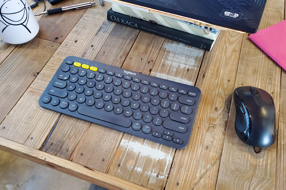 The Logitech K380 keyboard on a wood table.