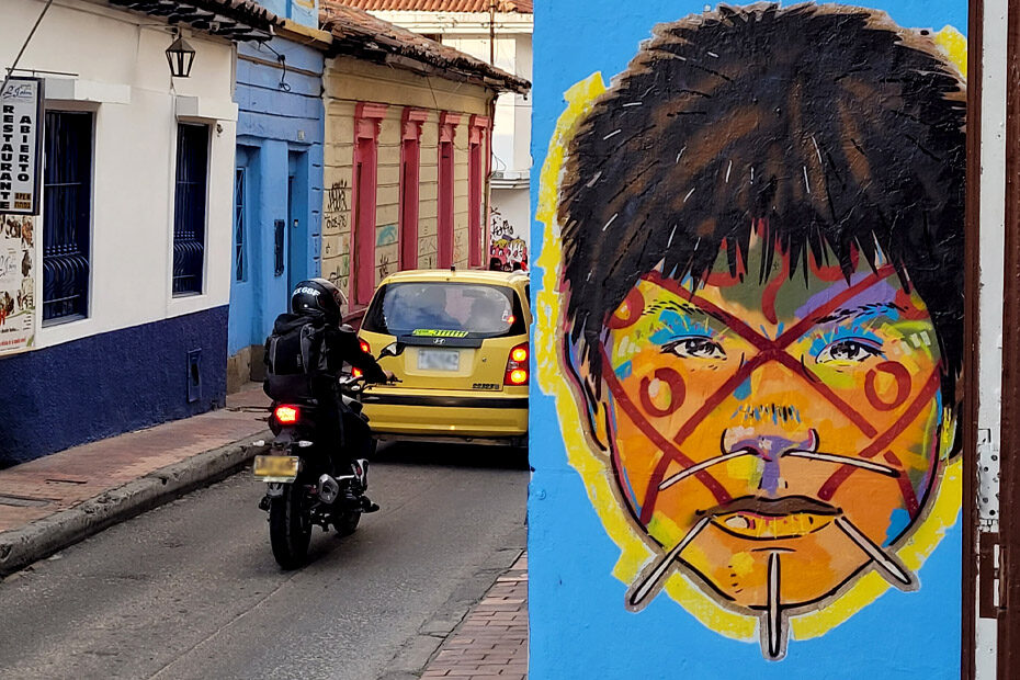 The face of an indigenous person painted on a wall stares back at the viewer, on a street art tour of Bogota's Candelaria neighbourhood