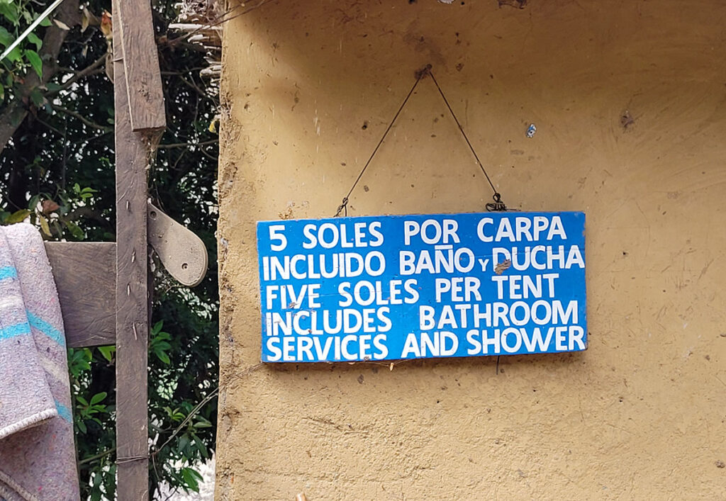 Sign at Santa Rosa Baja, on the trek to Choquequirao. It says: "5 SOLES POR CARPA INCLUIDO BANO Y DUCHA. FIVE SOLES PER TENT INCLUDES BATHROOM SERVICES AND SHOWER."
