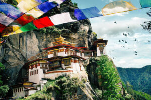 The Tiger Nest monastery, perched on the side of a steep mountain, with prayer flags fluttering in the foreground, in Bhutan .This is one of its most popular sites for tourists, who will now be paying a $200 USD daily Sustainable Development Fee